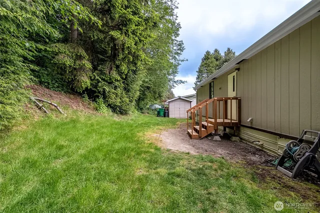 a view of a backyard with couches and table and chairs under an umbrella