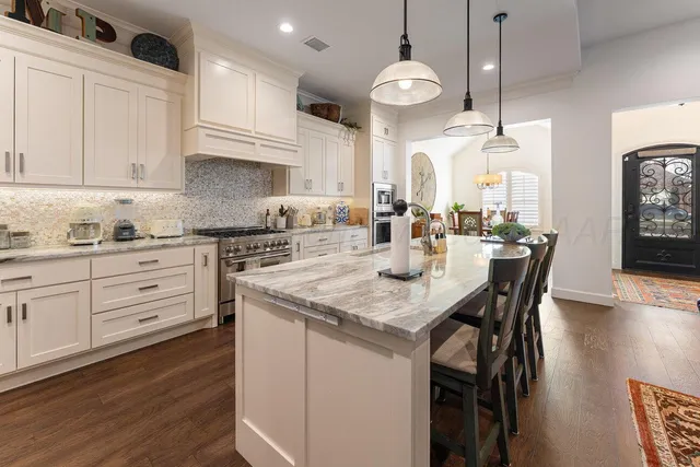 a kitchen with a table chairs stove and cabinets