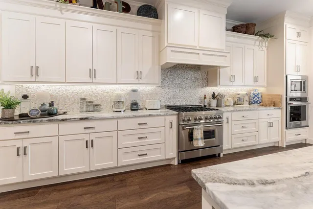 a kitchen with granite countertop white cabinets and white appliances