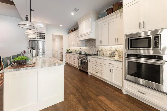 a kitchen with stainless steel appliances a stove sink microwave and cabinets