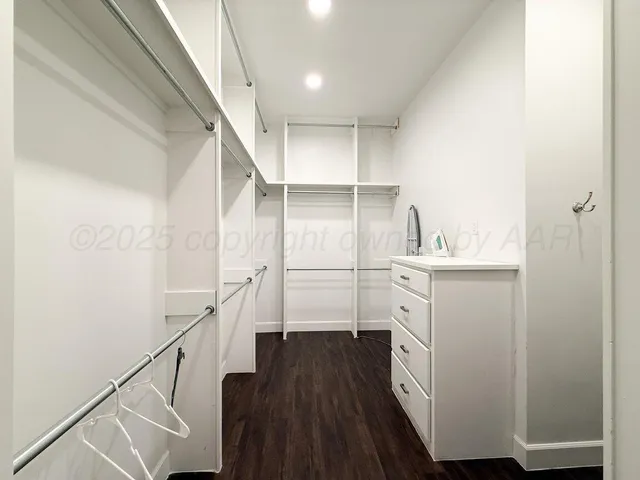 a bedroom with a bed and a flat tv screen on the dresser