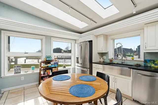 a kitchen with stainless steel appliances granite countertop a stove a sink a dining table and chairs