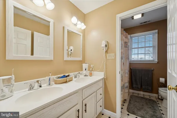 a en suite bathroom with a double vanity sink a mirror and a
