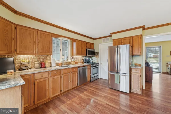 a kitchen with stainless steel appliances granite countertop a refrigerator and a stove top oven