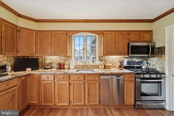 a kitchen with granite countertop a stove top oven sink and cabinets