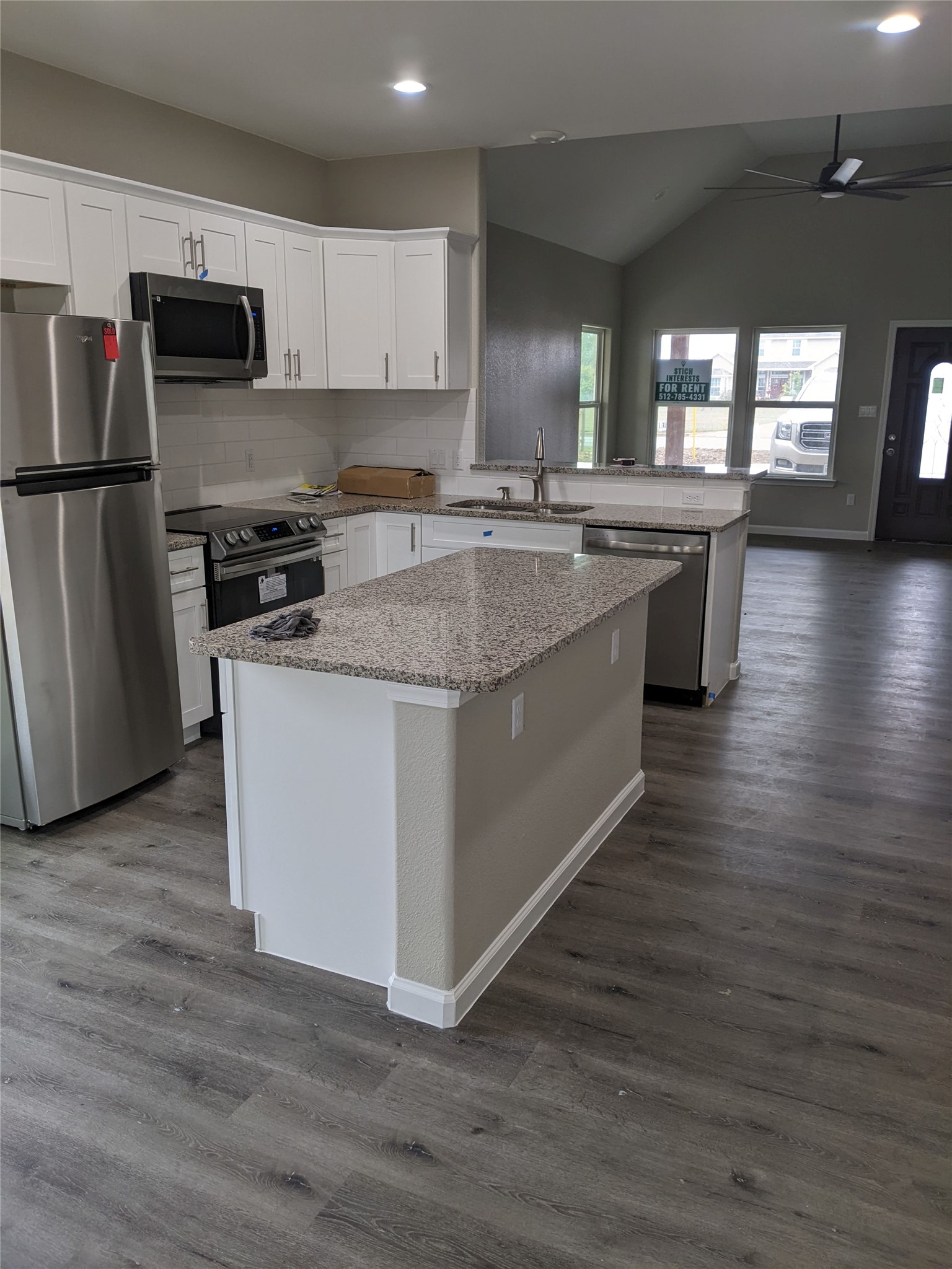 906 Kate Street, Unit A Lockhart, TX 78644 - Photo 15 of 15 Kitchen with stainless steel appliances, open floor plan, a ceiling fan, white cabinetry, and a kitchen island