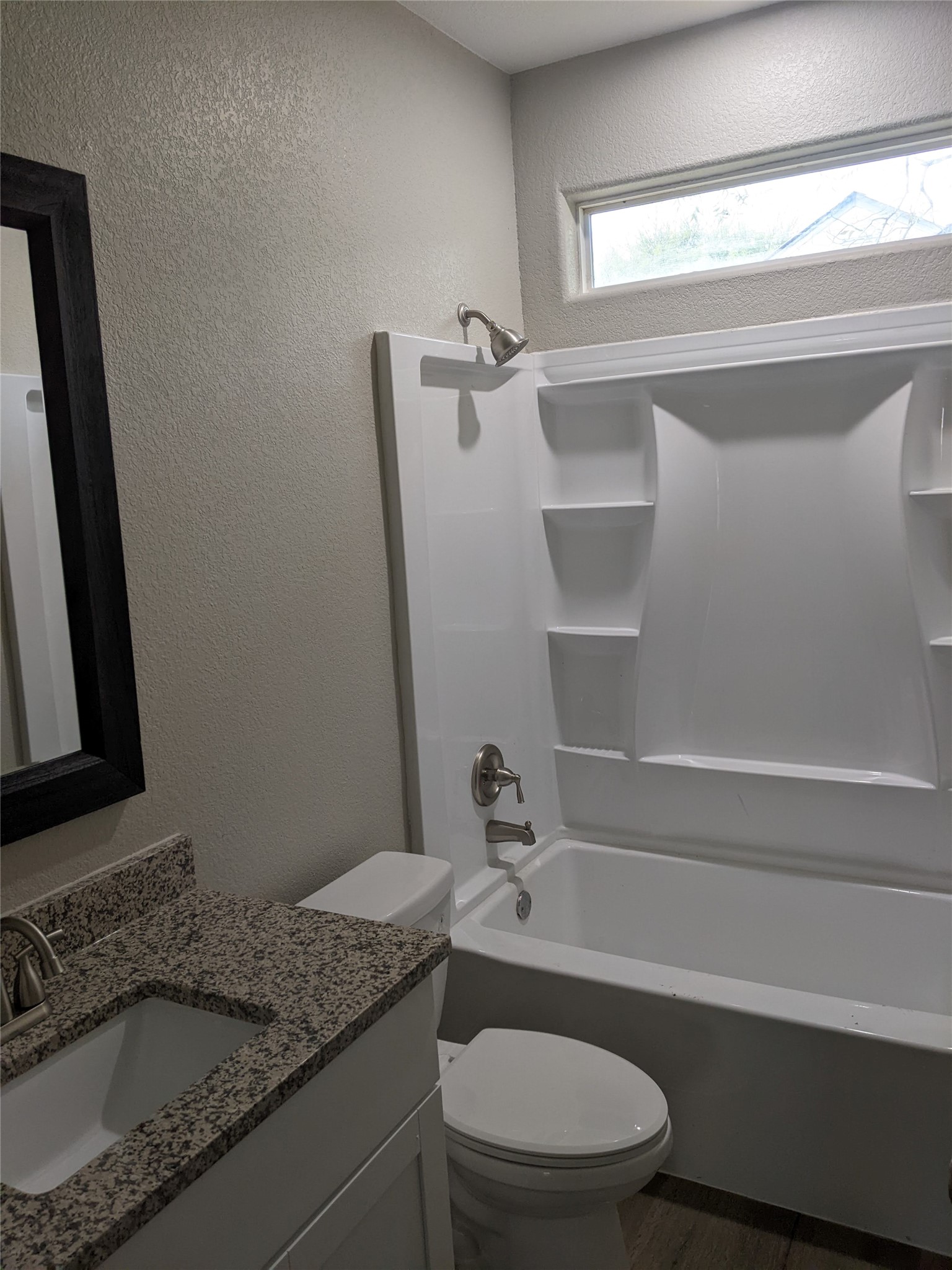 906 Kate Street, Unit A Lockhart, TX 78644 - Photo 7 of 15 Full bath with a textured wall, vanity, shower / tub combination, and dark wood-style vinyl flooring