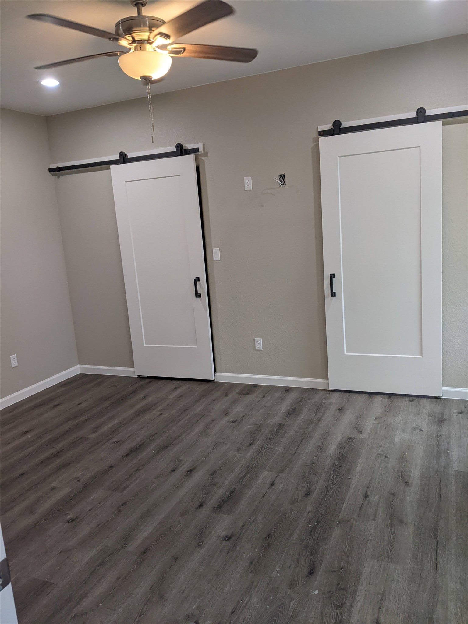 906 Kate Street, Unit A Lockhart, TX 78644 - Photo 9 of 15 Spare room with a barn door, a ceiling fan, dark wood finished floors, and recessed lighting