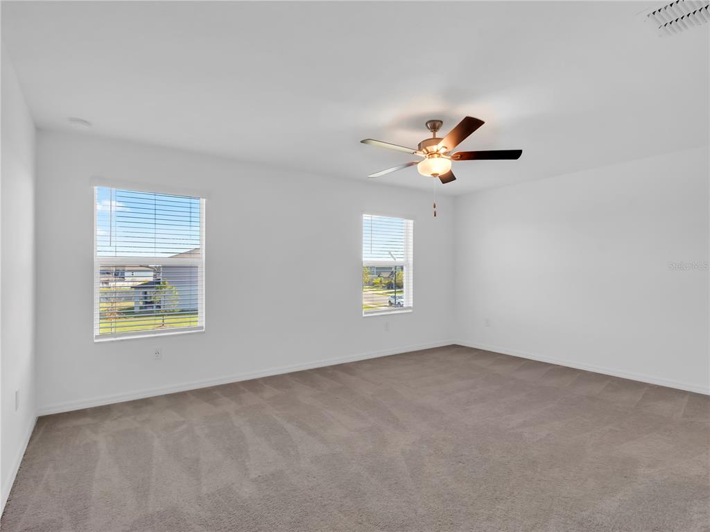 12408 Crystal Jade Way Parrish, FL 34219 - Photo 23 of 51 an empty room with a window and a ceiling fan