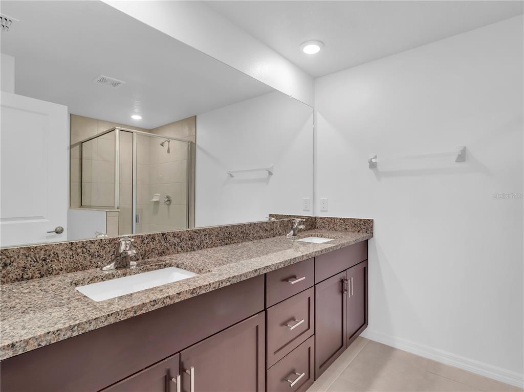 12408 Crystal Jade Way Parrish, FL 34219 - Photo 26 of 51 a bathroom with a granite countertop double sink and a mirror