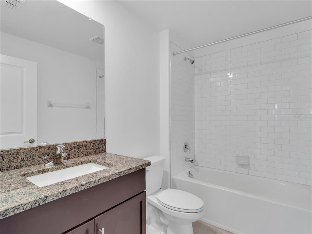 12408 Crystal Jade Way Parrish, FL 34219 - Photo 3 of 51 a bathroom with a granite countertop sink toilet and shower