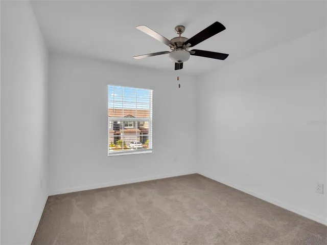 an empty room with a window and a fan