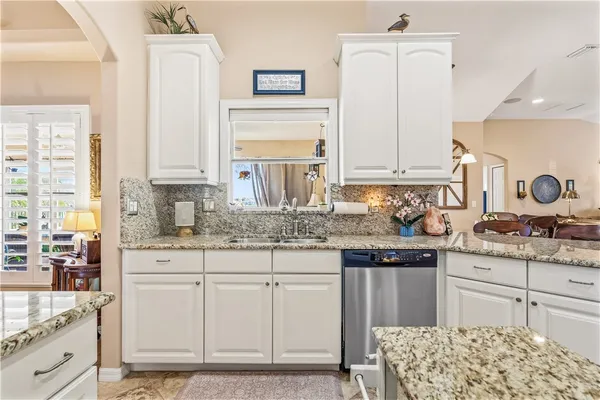 a kitchen with granite countertop white cabinets and white appliances