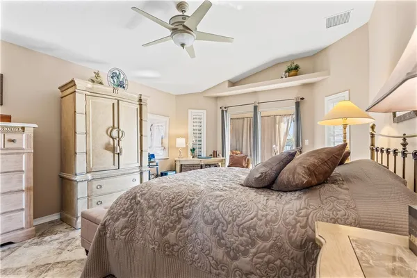 a bedroom with a bed a window and a chandelier
