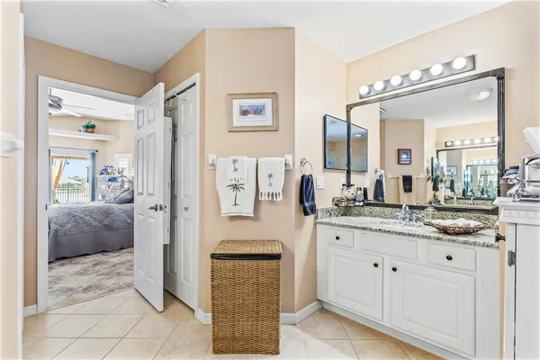a en suite bathroom with a granite countertop sink and a mirror
