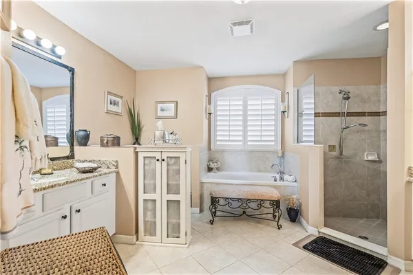 a spacious bathroom with a double vanity sink a mirror and a bathtub