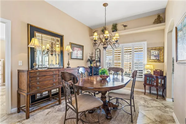 a dining room with furniture a chandelier and window
