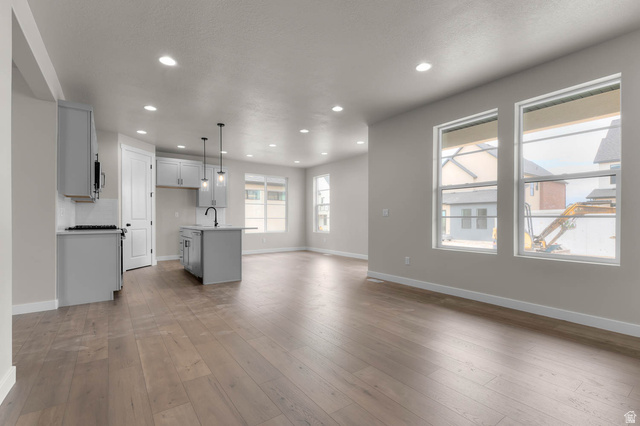 1567 North 3250 West Provo, UT 84601 - Photo 9 of 22 Open-concept living area with wood-finish flooring, recessed lighting, and multiple windows