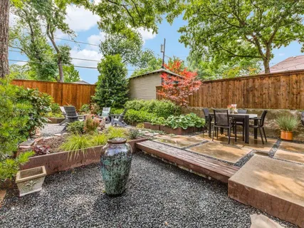 a view of backyard with table and chairs and potted plants