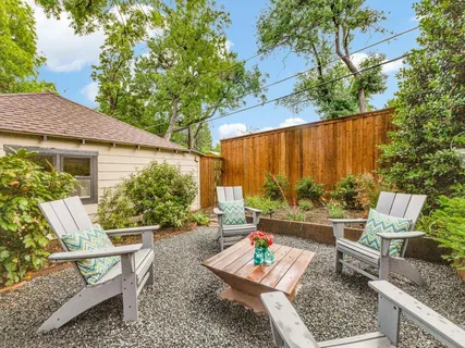a view of a patio with couches chairs potted plants and a large tree