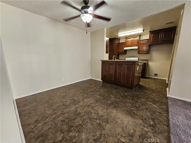 an empty room with kitchen view