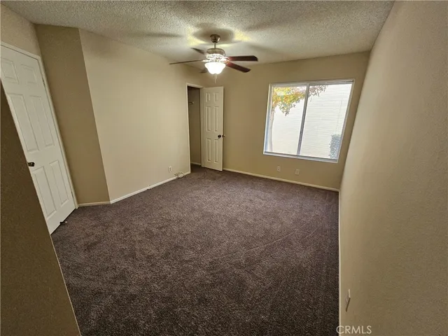 an empty room with a chandelier fan and a mirror