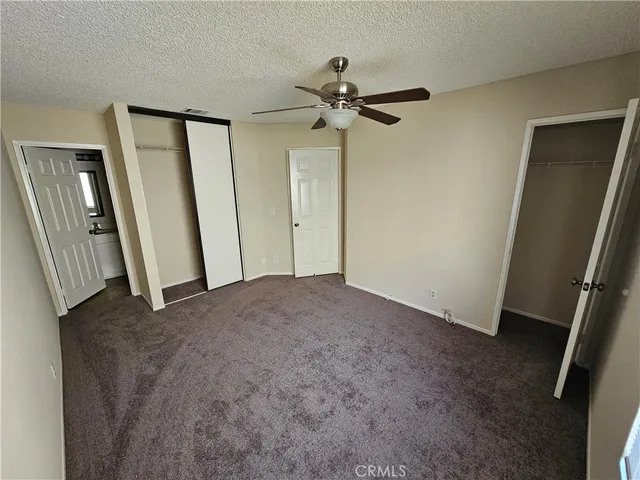 an empty room with windows and a ceiling fan