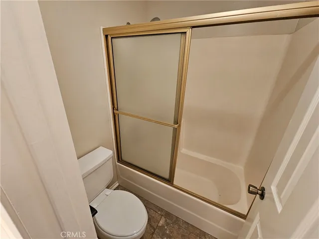 a bathroom with a granite countertop toilet and a shower