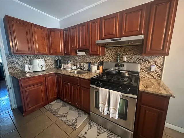 a kitchen with granite countertop wood cabinets stainless steel appliances and a sink