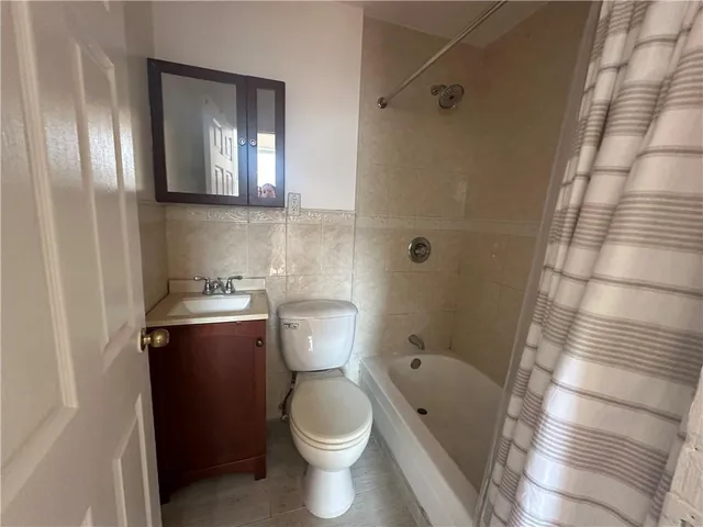 a bathroom with a granite countertop toilet and a shower