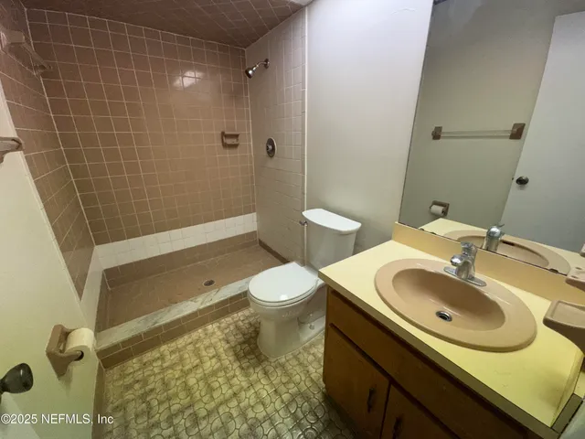 a view of wooden floor and a chandelier fan in a room