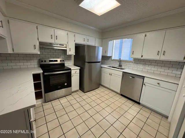 a kitchen with stainless steel appliances a sink and a refrigerator
