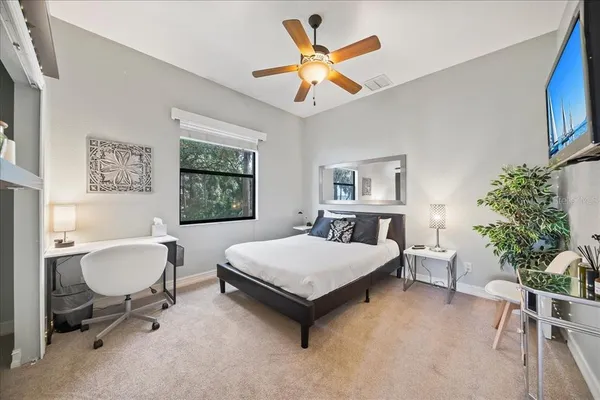 a living room with furniture a rug and a ceiling fan