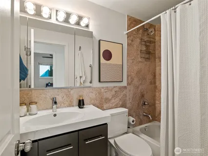 a bathroom with a sink vanity mirror and toilet