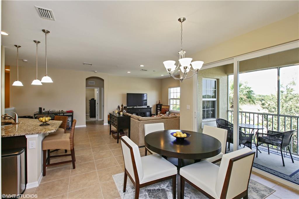 8540 Violeta Street, Unit 202 Estero, FL 34135 - Photo 12 of 22 a view of a dining room with furniture a chandelier and large windows