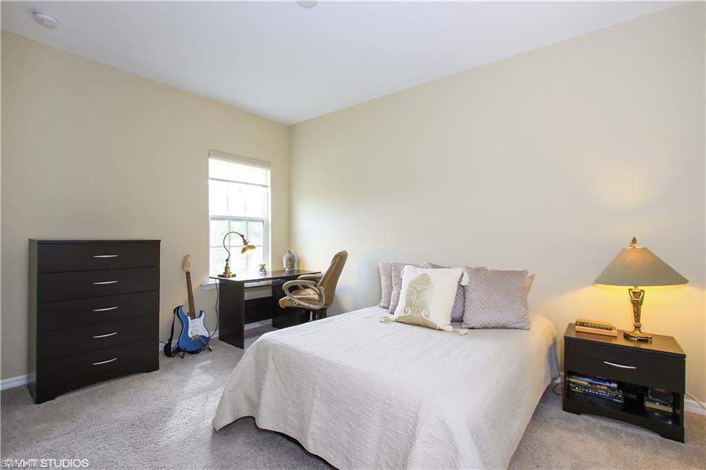 8540 Violeta Street, Unit 202 Estero, FL 34135 - Photo 17 of 22 a bedroom with a bed and a lamp
