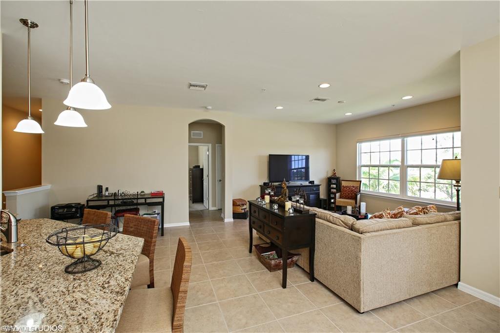 8540 Violeta Street, Unit 202 Estero, FL 34135 - Photo 9 of 22 a living room with furniture a flat screen tv and a large window