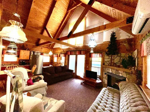 a living room with furniture a flat screen tv and a floor to ceiling window