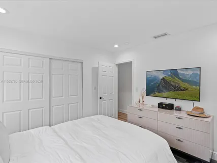 a bedroom with a bed and a flat screen tv
