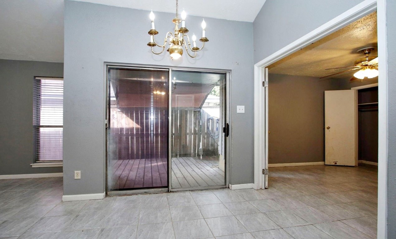 3111 Oak Rock Spring, TX 77373 - Photo 7 of 21 an empty room with chandelier fan and windows