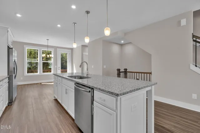 a kitchen with stainless steel appliances a stove a microwave and a hard wood floors