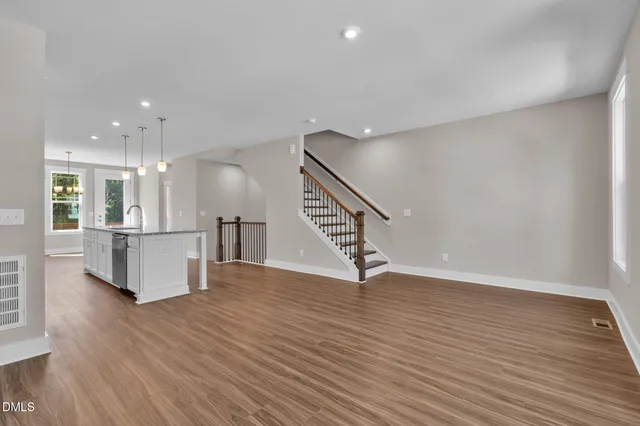 a view of empty room with wooden floor and window