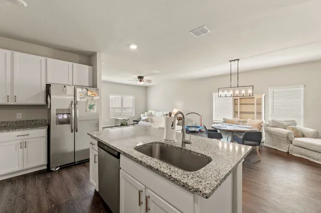 a kitchen with stainless steel appliances granite countertop a sink a stove and a refrigerator