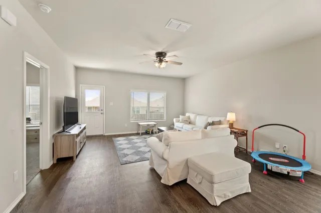 a living room with furniture and wooden floor