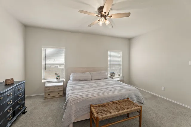 a bedroom with a bed a chandelier and a window