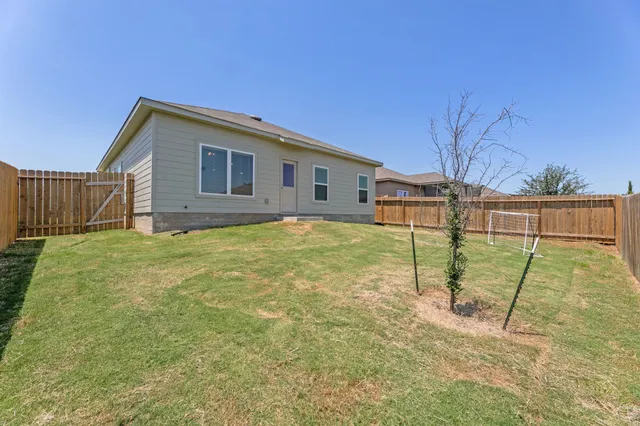 a backyard of a house with table and chairs