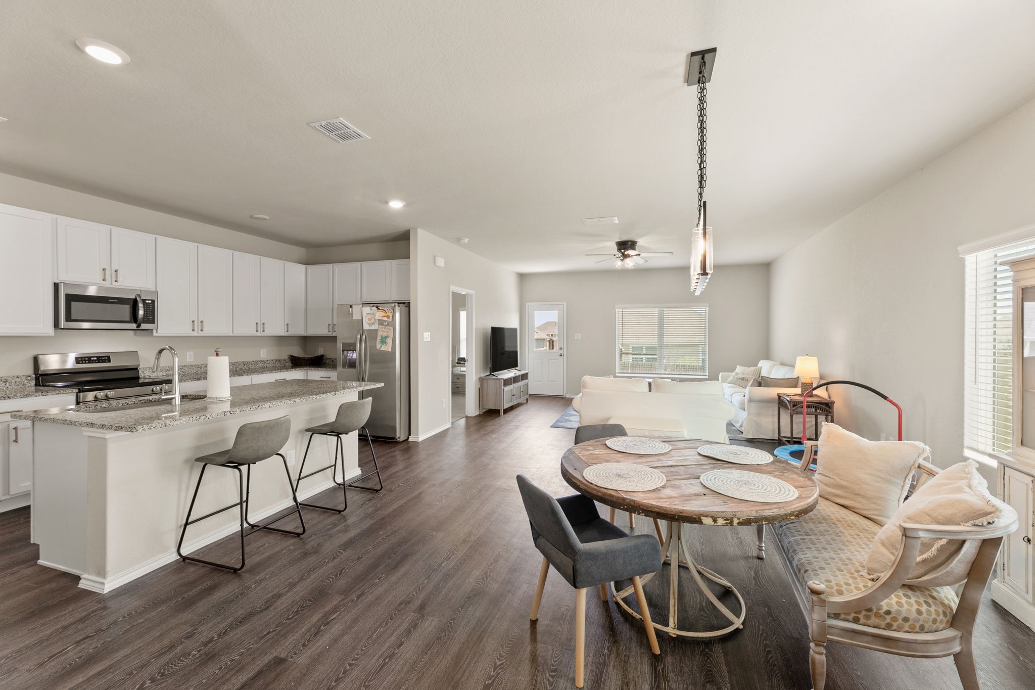 3969 Legend Ranch New Braunfels, TX 78130 - Photo 5 of 32 a kitchen with stainless steel appliances kitchen island granite countertop a dining table chairs and sink