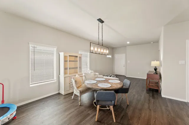 a dining room with furniture a chandelier and wooden floor