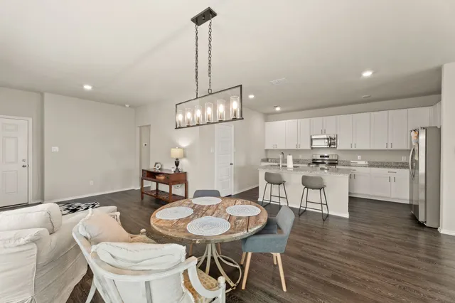 a kitchen with a dining table chairs sink and stove