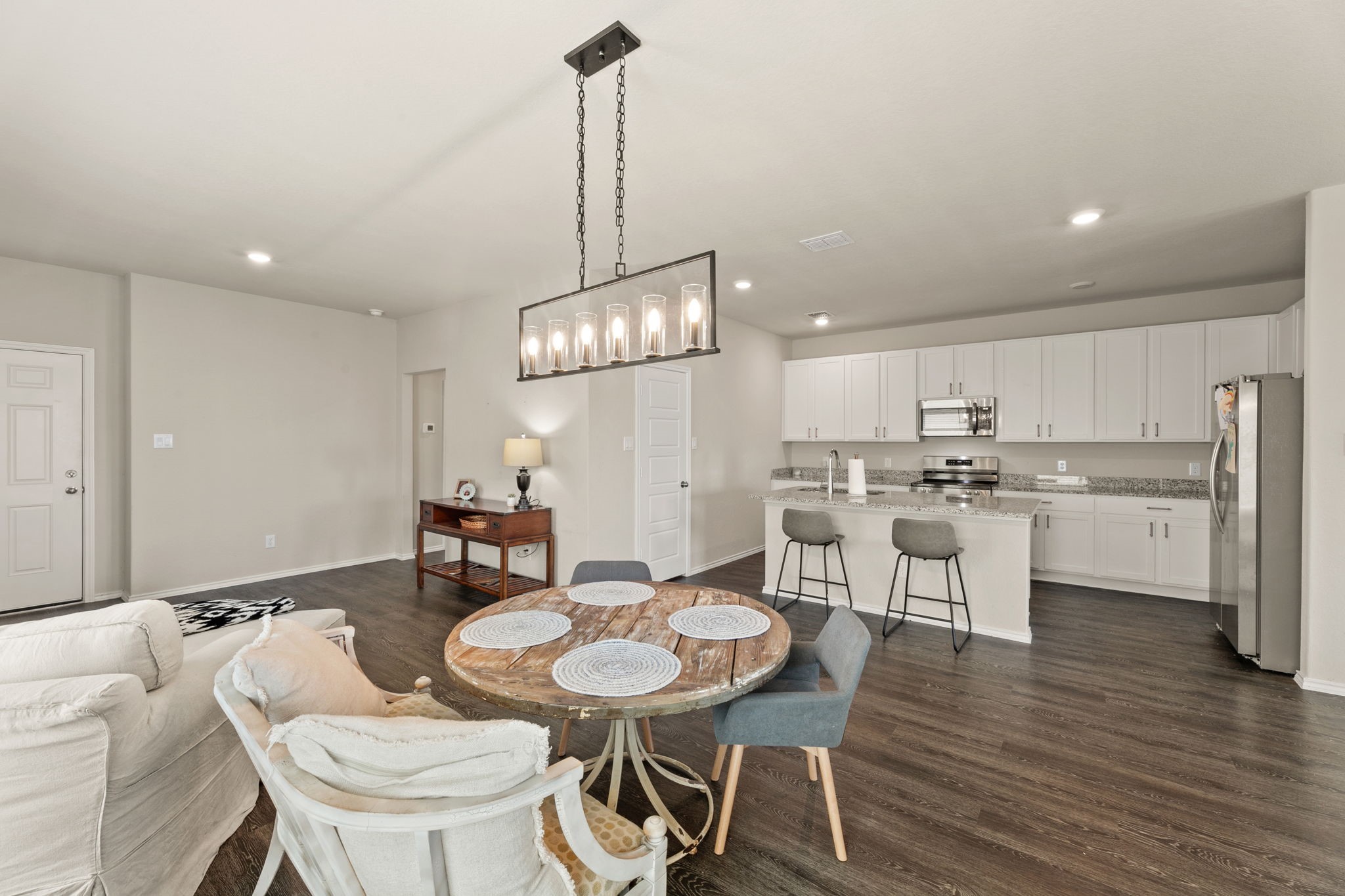 3969 Legend Ranch New Braunfels, TX 78130 - Photo 7 of 32 a kitchen with a dining table chairs sink and stove